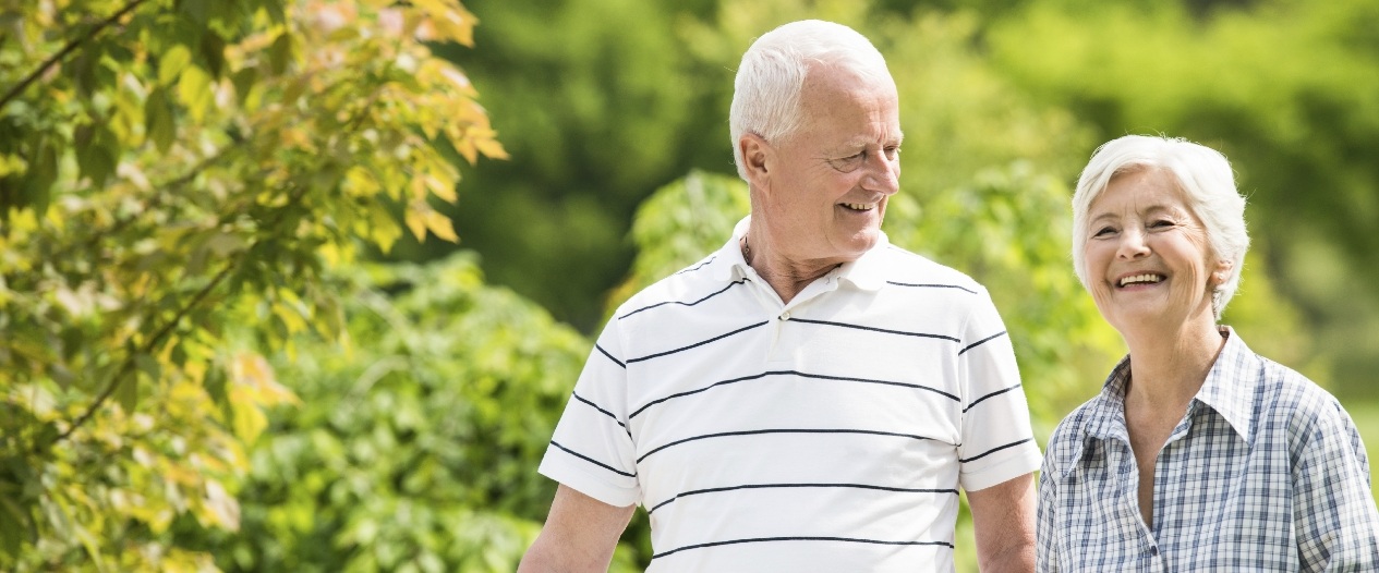 Senior couple outdoors smiling with dental implants in Mount Prospect