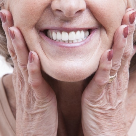 Close up of smiling senior woman touching her cheeks