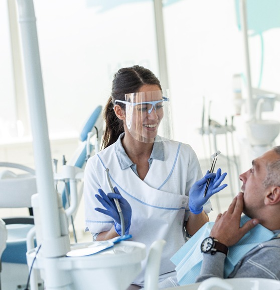 Dentist explaining treatment to patient sitting in treatment chair