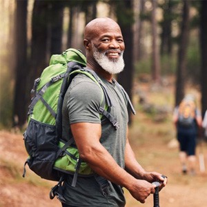 a man smiling while on a hike in the woods