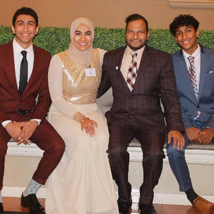 Doctor Khan with her husband and two sons in formal clothing
